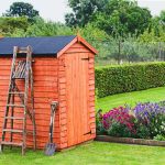 Timber apex garden shed with a black Skyguard EPDM rubber roof, ladder and garden fork