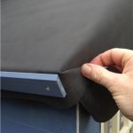 Hand folding Skyguard EPDM membrane over the corner of a blue timber playhouse roof